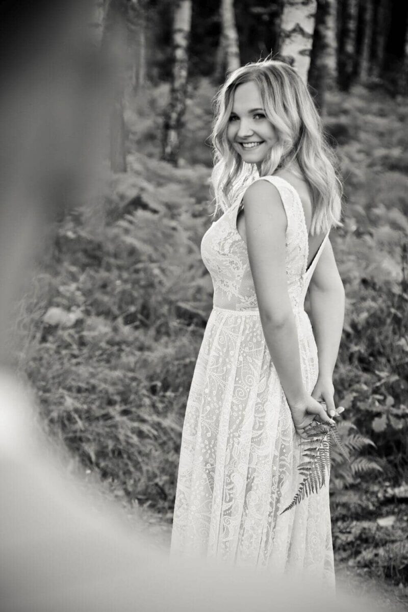 Suknia ślubna w stylu boho Porto 47 z tasiemką na plecach zamiast bogatej krawędzi koronki, a w spódnicy rozcięcie na nogę z wstawką z tiulu.