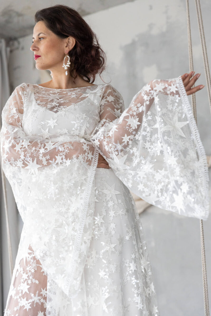 Suknia ślubna w gwiazdy z cekinami i rozszerzanymi rękawami